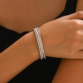 Elegant triple-layer bridal bracelet with crystals and pearls on a model's wrist - Silver