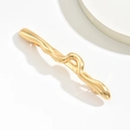 Dettaglio della molletta per capelli dorata a onde con finitura lucida a specchio - Stile Ondulato Oro