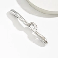 Dettaglio di un fermaglio per capelli ondulato argento con finitura in metallo liquido - Stile Ondulato Argento