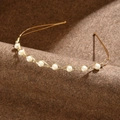 Dettaglio del cerchietto con perle coreano con montatura dorata ondulata e strass - Oro