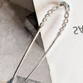 Dettaglio di forcina a U argentata con design a corda intrecciata e pietre verdi - Argento