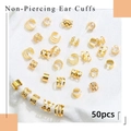 Dettaglio di 50 ear cuff dorati non perforati con diversi motivi geometrici in metallo - Oro