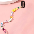 Dettaglio di perline colorate con sorrisi e cuori su un fermaglio per capelli nero - Stile A