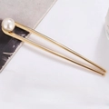 Minimalist U-shaped gold metal hair pin with large white pearl on a clean background - Gold Pearl Style