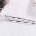 Detail view of a silver U-shaped hair pin with a single white pearl on a white surface - Silver Pearl Style