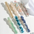 Set of 7 wavy acetate hair clips in colorful marble patterns on a white background - 7-Pack Set
