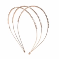 Detalle de tres diademas de oro rosa con pedrería brillante sobre fondo blanco minimalista - Estilo de Tres Capas / Oro rosa