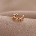 Minimalistischer U-förmiger goldener Stern-Ohrclip auf strukturiertem Stoffhintergrund - Gold