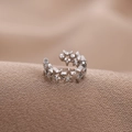 Minimalistische silberne U-förmige Stern-Ohrklemme ohne Piercing auf braunem Stoff - Silber