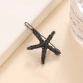 Dettaglio del fermaglio per capelli a stella marina con strass neri e base in metallo - Nero