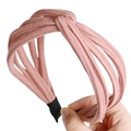 Détail d'un serre-tête rose noué en tissu doux texturé avec embouts de protection - Rose