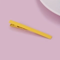 Detail view of a bright yellow matte metal hair clip with anti-slip teeth on pink background - Yellow