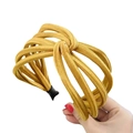 Close-up of mustard yellow fabric headband with knotted design and comfort end tips - Yellow