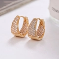 Close-up of golden U-shaped earrings with micro-paved cubic zirconia and snap closure - Gold