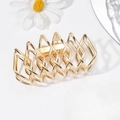 Macro-opname van de grote gouden geometrische metalen haarklem met gepolijste finish - Goud