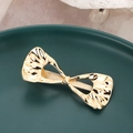 Irreguläre goldene Schleife Metall Haarspange mit Wellentextur auf dunklem Teller - Gold