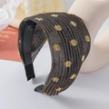 Détail d'un large serre-tête plissé en tissu pailleté doré sur une tête de mannequin - Café