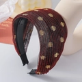 Détail d'un serre-tête large rayé rouge et noir orné de paillettes dorées sur modèle - Bordeaux
