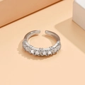 Detalle macro de un anillo ajustable plateado con siete circonitas redondas brillantes - Plateado