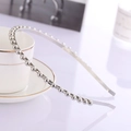 Cerchietto minimalista in metallo argento con perline su sfondo di tazza bianca - Argento