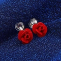 Eleganti orecchini a rosa rossa con cristalli a goccia scintillanti su uno sfondo blu intenso - Rosso