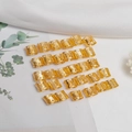 Golden hollow dreadlock rings with intricate patterns on elegant white fabric - Gold