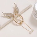 Detail view of gold angel wing hair clip with rhinestones, pearls and long tassel chains - Gold