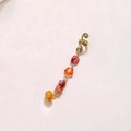 Dettaglio dell'anello per trecce a spirale dorata con ciondoli in pietra naturale colorata - Stile Corto Arancione (E9420)