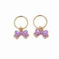 Detailed close-up of golden metal rings featuring purple enamel bow charms for hair and jewelry - Purple Bow Pair (E8531)