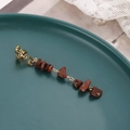 Macro detail of alloy spring braid accessory with red natural stone charms on a plate - Dark Red Short Style (E9427)