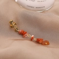 Élégant ear cuff doré avec de longs glands en pierre rouge sur fond de satin champagne - Style Court Rouge Orangé (E9108)