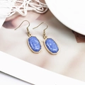 Detail der eleganten goldenen Sechseck-Ohrringe mit blauem Marmorstein-Inlay - Saphirblau