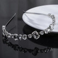 Elegante cerchietto argento con cristalli geometrici su una superficie nera riflettente - Argento