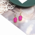Details von rosa Marmor-Ohrhängern mit Goldhaken auf einem Lifestyle-Hintergrund - Fuchsia
