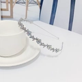 Close-up of silver flower headband with iridescent AB rhinestones by a coffee cup - Silver AB Rhinestone (D2131)
