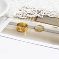 Close-up of gold animal hollow couple rings with adjustable opening on magazine - Dinosaur Gold (D2427)