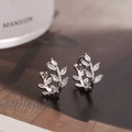 Makroaufnahme silberner Blatt-Creolen mit Zirkonia-Steinen im Marquise-Schliff - Silber
