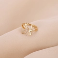 Anillo dorado ajustable KISS con labios de circón sobre fondo de seda rosa suave - Dorado