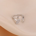 Anillo KISS ajustable plateado con letras de circonita sobre fondo de seda rosa - Plateado