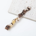 Detailopname van een golvende haarclip van acetaat met een bruin schildpadpatroon - Vintage Bruin Schildpadpatroon (M6413-5#)