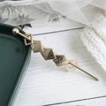 Minimalistische gouden geometrische haarspeld met ruitvormen op witte houten bodem - Goud Geborsteld Stijl (E7115)