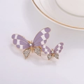 Macro detail of gold-edged purple butterfly hair clips with shimmering rhinestones - Purple