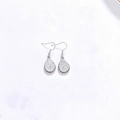 Vue détaillée des boucles d'oreilles argentées en goutte avec finition scintillante - Base Argent Argent