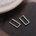 Orecchini a cerchio rettangolari in argento minimalisti su sfondo scuro strutturato - Argento