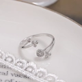 Vue détaillée d'une bague fleur ajustable en argent avec zircone pavée sur céramique blanche - Ouvert Réglable / Argent (D9403)