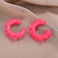 Orecchini a lobo a C rosa neon con trama 3D appuntita su sfondo di tessuto marrone - Rosa