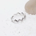 Makroaufnahme eines silberfarbenen Zickzack-Rings mit weißen Zirkonia in feinem Sand - Silber (D8312)
