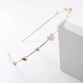 Detailed macro view of a thin gold metal headband featuring a pearl heart and rhinestones - Gold (C8132)