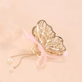 Detailed view of golden butterfly hair clip with pink ribbon and hanging imitation pearls - Hollow Butterfly Style (C2329) / Gold-Pink