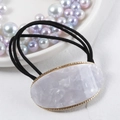 Macro detail of oval purple marble acetate hair tie with golden metallic frame edge - Simple White Marble Decor / White